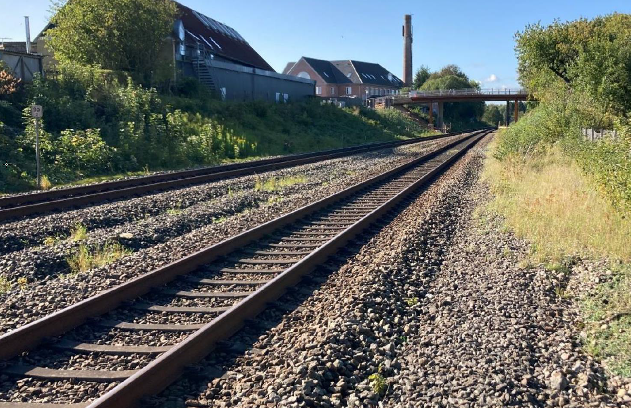 Jernbanestrækning ved Stilling. Sporet ses tæt på omgivet af træer.